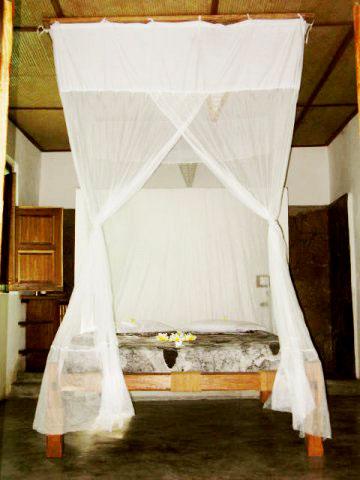 Quarto com cama de casal e mosquiteiro